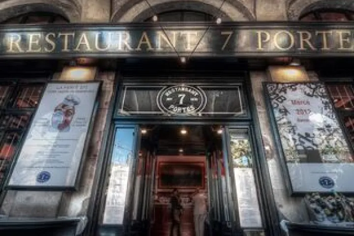 Historischer Eingang des Restaurants 7 Portes, eingerahmt von seinen Schildern und Menüs.