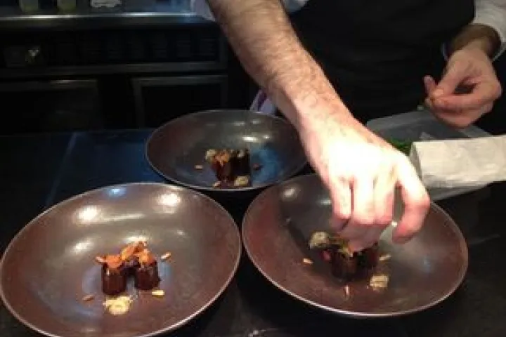A chef adds the finishing touch to plates in the kitchen at ABaC.