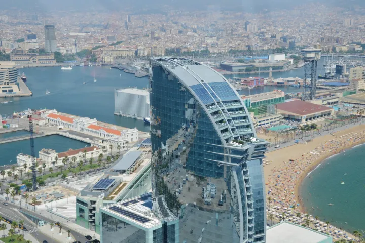 A praia de Sant Sebastià vista de cima, com o hotel W e a entrada do porto