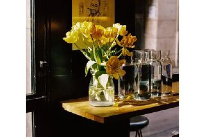 Small counter at Berbena with a bouquet of yellow flowers and glasses.