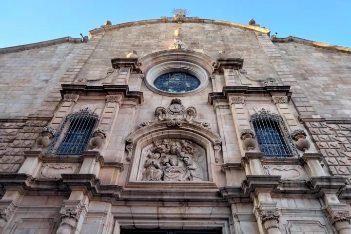 Le haut de la façade principale de l'église de Betlem, son fronton ondulé, son oculus et ses fenêtres grillagées