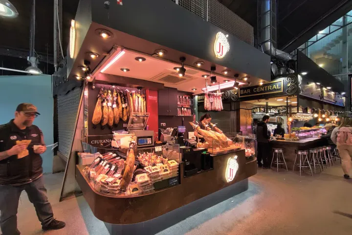 Die hängenden Schinken und Wurstwaren an einem Stand der Boqueria