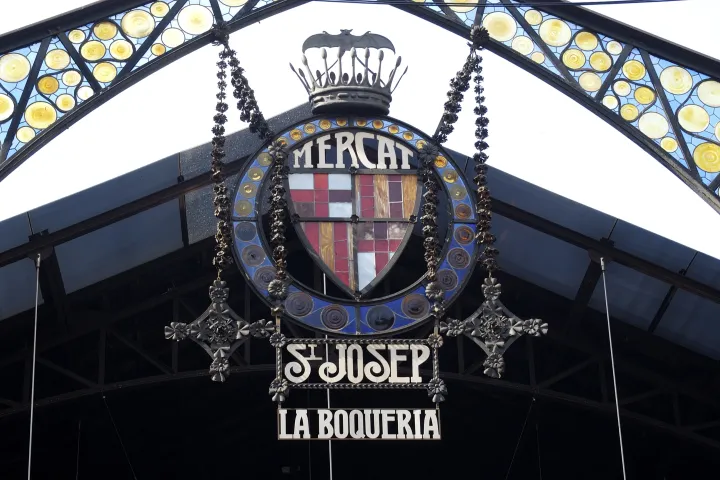 Das modernistische Portal der Boqueria, sein buntes Glasfenster und das Wappen von Barcelona