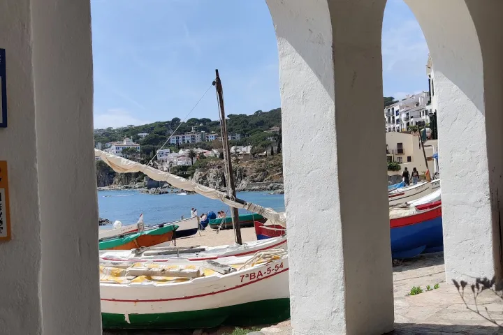 The white arches of Calella de Palafrugell frame the boats and the beach, facing the Mediterranean.