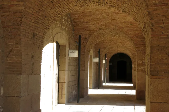 La galería abovedada de ladrillos que bordea el patio de armas del castillo de Montjuïc