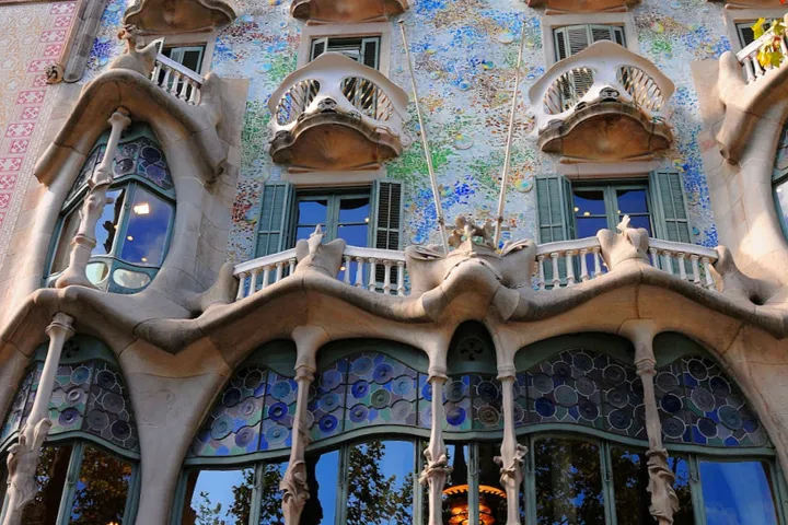 La fachada ondulante de la Casa Batlló, sus balcones en forma de máscaras y su mosaico de vidrio azul y verde