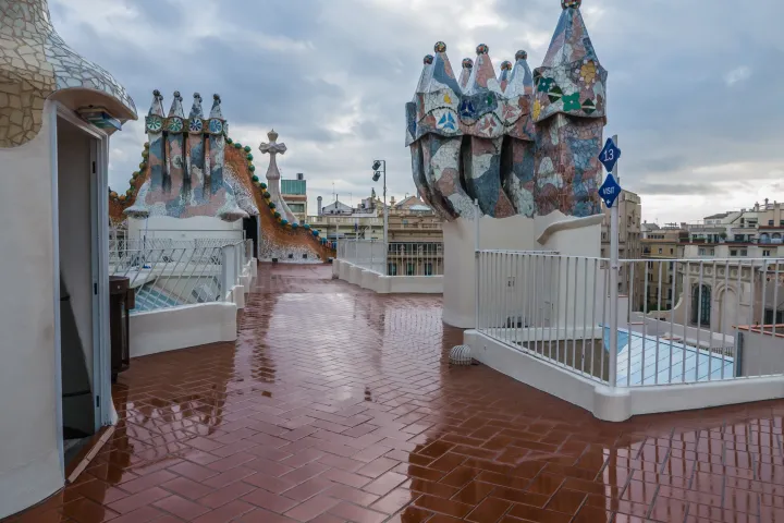 Las chimeneas escultóricas cubiertas de trencadís en la terraza de la Casa Batlló, frente a la cresta del dragón