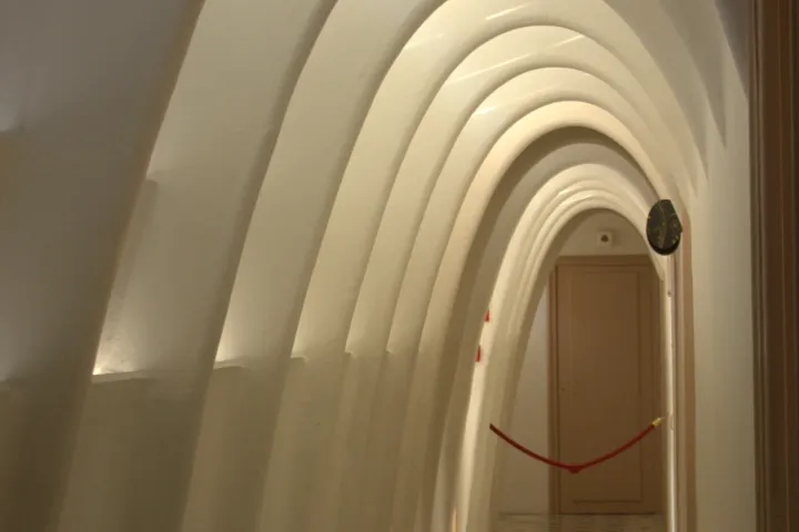 El pasillo de las buhardillas y su sucesión de arcos parabólicos blancos, evocando una caja torácica