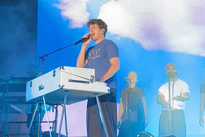 Charlie Puth sings at his keyboard on the Poble Espanyol stage, under the spotlights, with the audience in the foreground