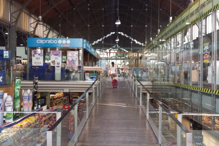 Die innere Gasse des Mercat de la Concepció unter dem Eisendach, gesäumt von Kühlvitrinen