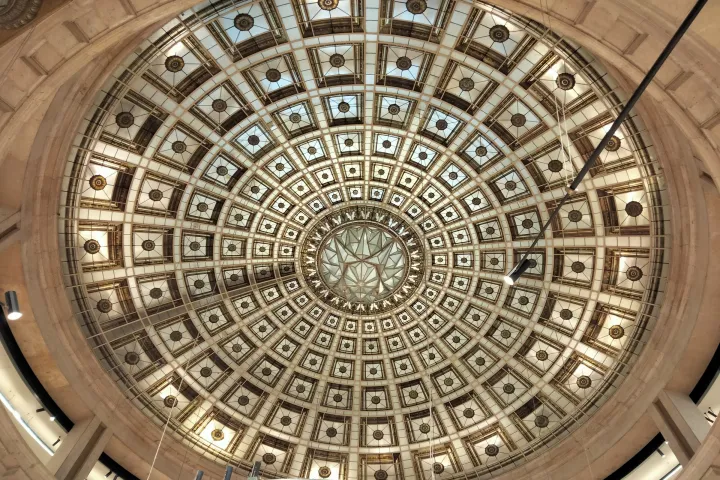 Vista de baixo para cima da cúpula de vidro com padrões geométricos do Zara na Plaça de Catalunya.