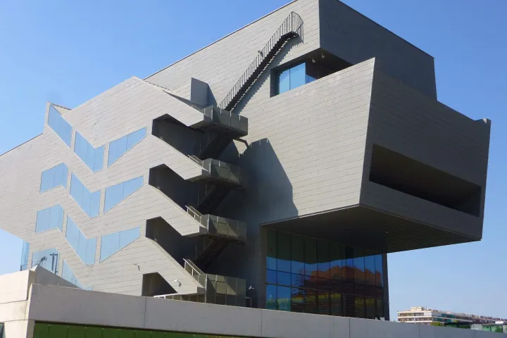 O edifício cinza do Disseny Hub, com seus volumes em balanço e suas escadas externas em zigue-zague