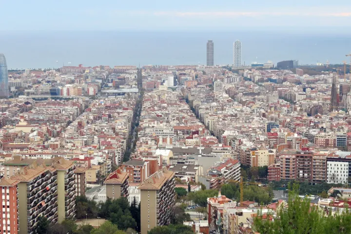 La griglia dell'Eixample vista dal Turó de la Rovira, con le sue strade rettilinee che si dirigono verso il mare, la Sagrada Família e la Torre Glòries