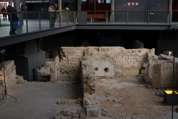As paredes de pedra do bairro de La Ribera desenterradas sob o mercado, sobrepostas por uma passarela onde passam visitantes