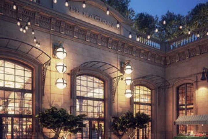 Illuminated facade of El Nacional, featuring large arched windows, at dusk.