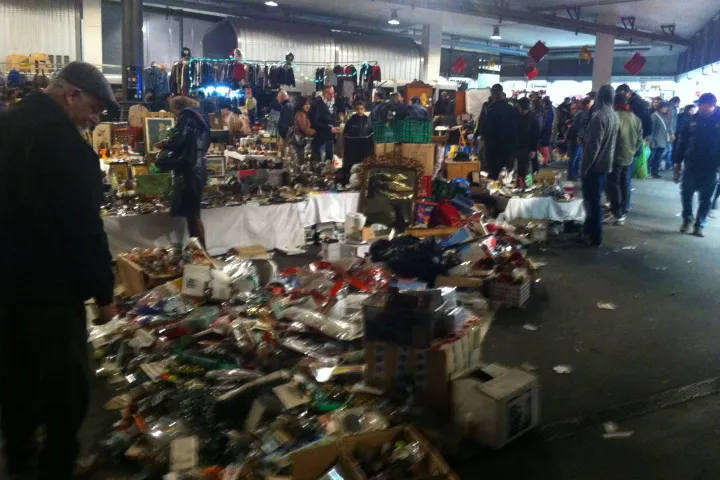 Second-hand items spread out on the ground between the aisles of Mercat dels Encants, with bargain hunters rummaging through