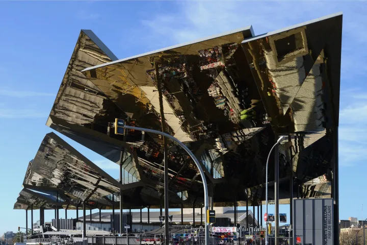 The large golden canopy of the Mercat dels Encants seen from the street, its inclined planes reflecting the market