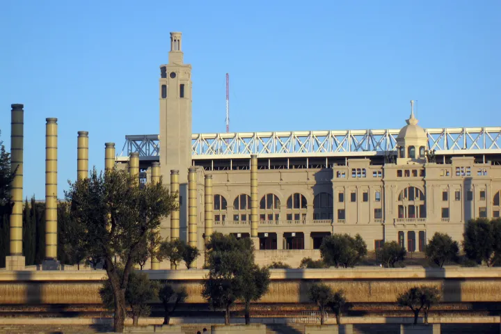 La fachada monumental del Estadio Olímpico Lluís Companys y su torre-reloj, bajo un cielo azul