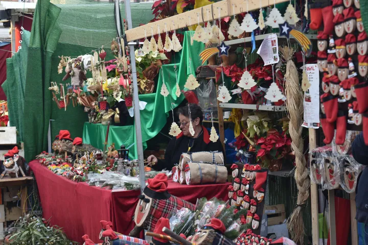 Eine Verkäuferin in ihrem Kunsthandwerks- und Geschenkestand auf der Fira de Nadal