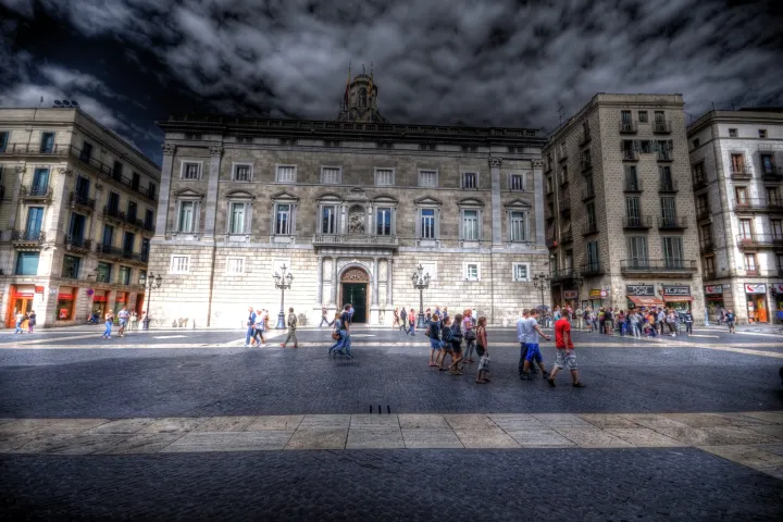 La façade du Palais de la Generalitat sur la plaça de Sant Jaume, avec les passants sur les pavés de la place