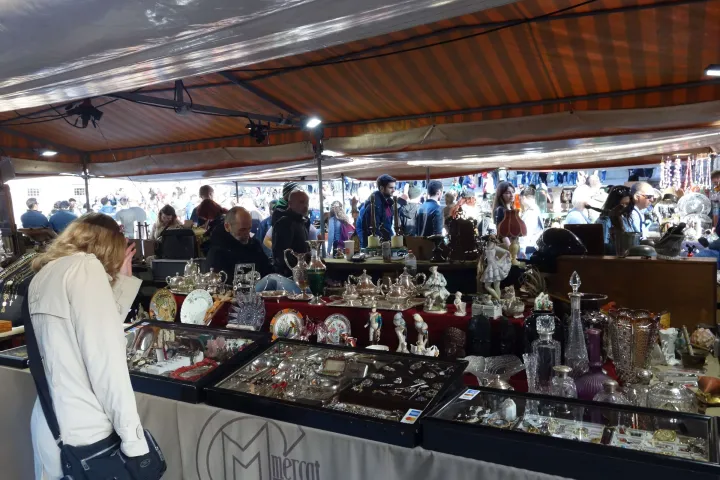Una vetrina del Mercato Gotico adornata con gioielli antichi, caraffe di vetro e pezzi di argenteria