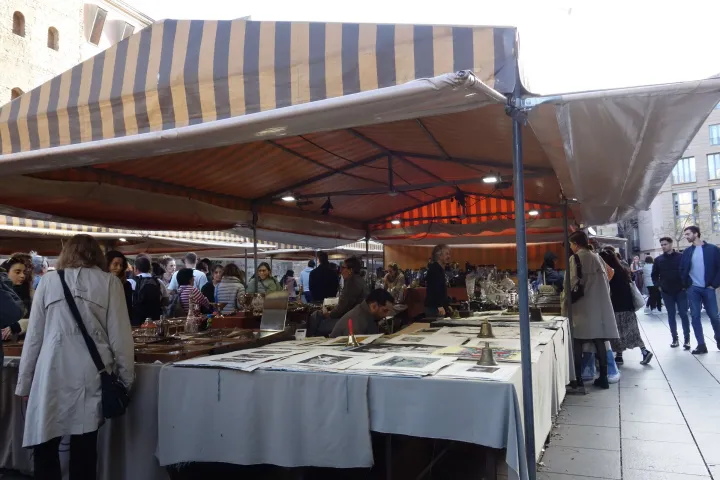 Una bancarella del Mercato Gotico coperta di disegni, incisioni e litografie antiche sotto i teli a righe