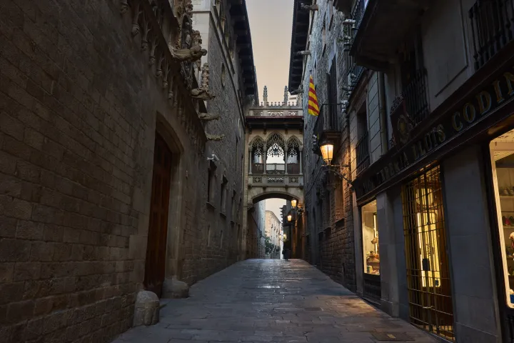 A ponte neogótica do Carrer del Bisbe atravessa a viela pavimentada, entre o Palau de la Generalitat e a Casa dels Canonges
