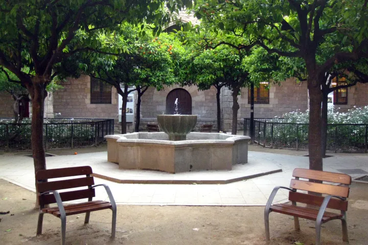 Il cortile piantumato di aranci dell'antico Ospedale di Santa Creu, la sua fontana centrale e le sue panchine