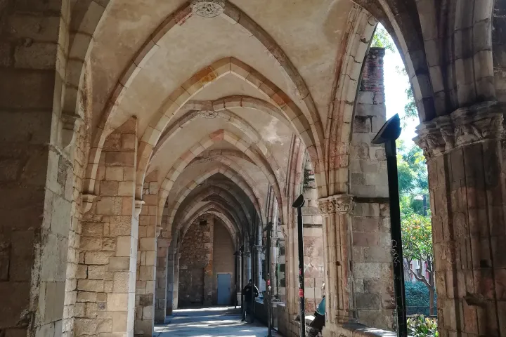 Una galleria gotica a volta dell'antico Ospedale di Santa Creu, in fila verso il cortile