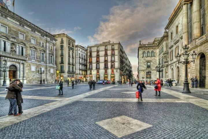 La Plaça Sant Jaume vista dal suo centro, con il Municipio da un lato e il Palau de la Generalitat dall'altro, che si fronteggiano