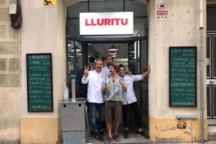 The Lluritu team in front of the restaurant door, between two chalkboards.
