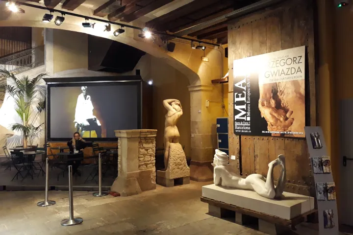 Figurative stone and marble sculptures arranged in the vaulted hall of the Palau Gomis