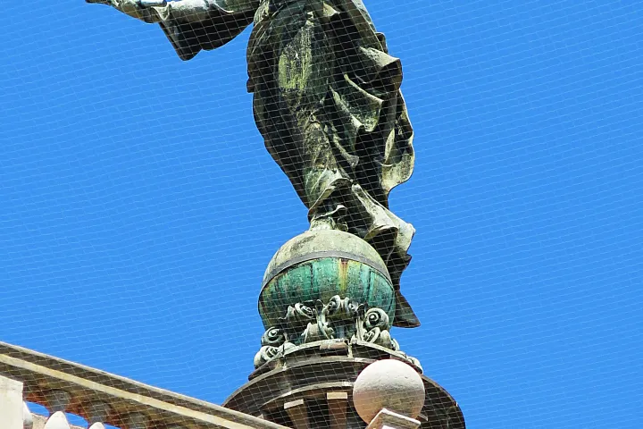 La estatua de bronce de la Virgen de la Mercè en la cima de la cúpula, destacándose contra el cielo