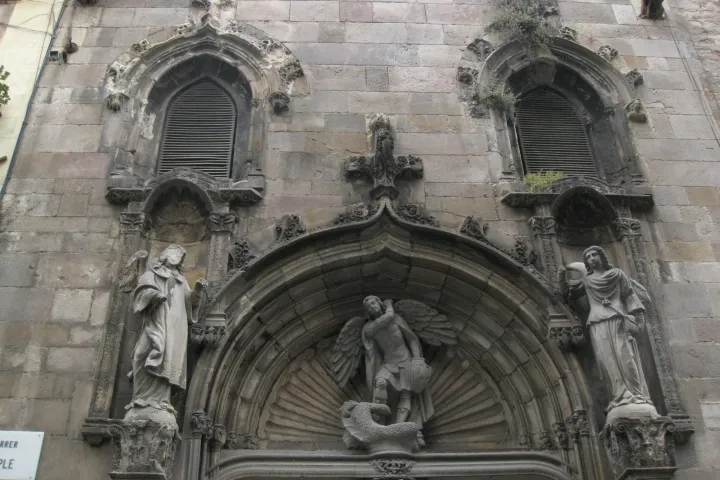 El portal renacentista de Sant Miquel en el lateral de la basílica, su tímpano esculpido y sus estatuas