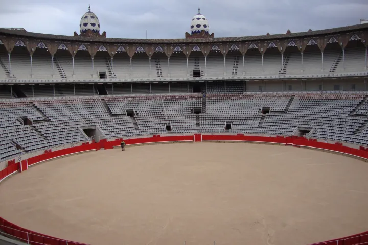 La arena vacía de La Monumental, su pista de arena rodeada de rojo y sus gradas escalonadas bajo los arcos