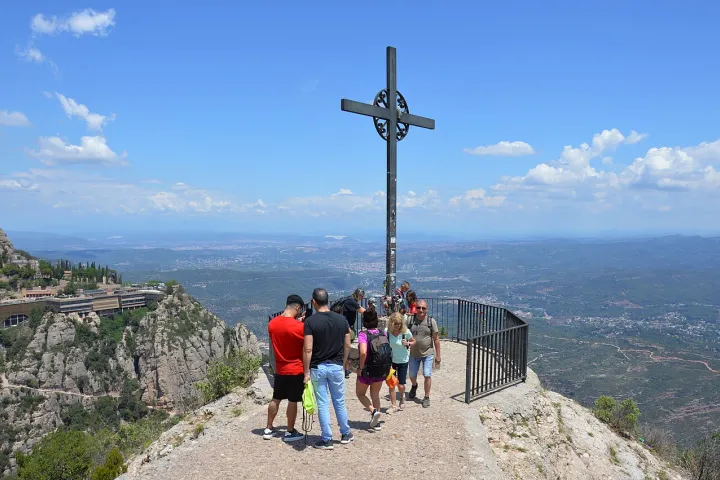 A cruz de Sant Miquel domina um mirante onde os visitantes observam as paisagens e a planície a partir de Montserrat.