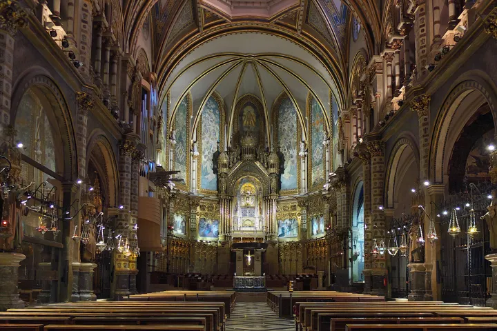 A nave da basílica de Montserrat, com seus bancos de madeira, suas abóbadas ornamentadas e seu altar-mor.