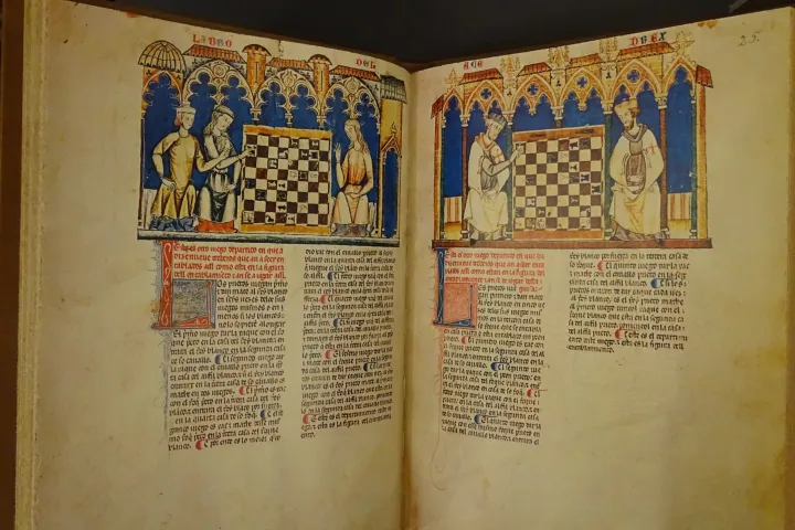Un manuscrit enluminé ouvert sur deux pages, montrant des joueurs d’échecs sous des arcades gothiques