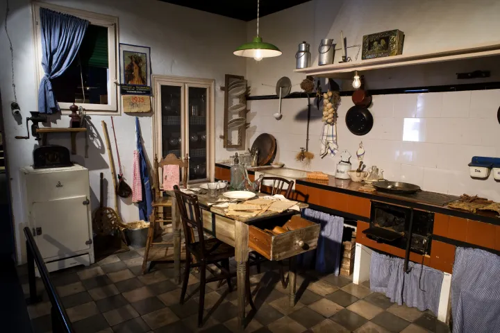 La reconstitution d'une cuisine populaire des années 1930, avec sa cuisinière à charbon, sa glacière et sa table encombrée