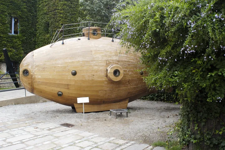 La réplica de madera del submarino Ictíneo, con sus ojos de buey redondos, situada en el jardín del museo