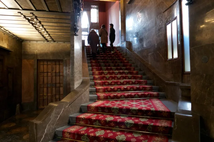 Die Ehrentreppe des Palau Güell, roter Teppich und dunkle Holzvertäfelungen führen zum Hauptgeschoss