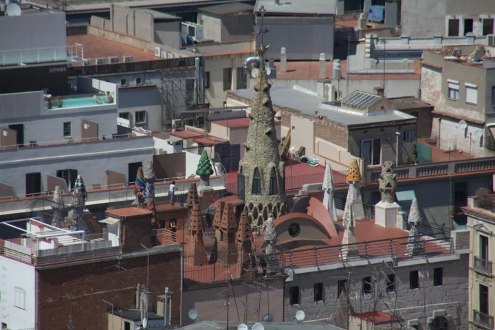 Die Dachterrasse des Palau Güell und seine mit Trencadís verkleideten Schornsteine über den Dächern des Raval