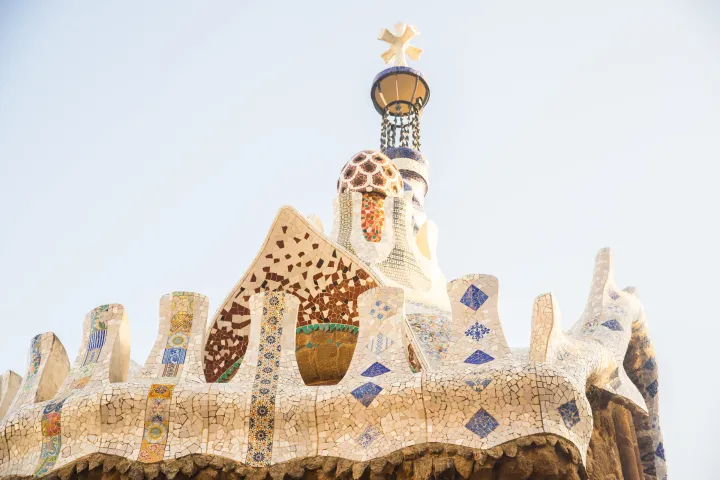 La cresta del padiglione d'ingresso del Parc Güell coperta di trencadís, frammenti di ceramica bianchi e colorati