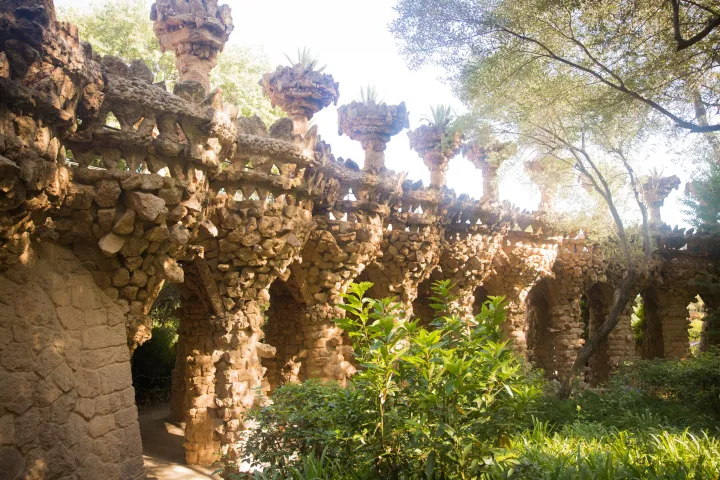 Un viadotto del Parco Güell che segue la pendenza, sormontato da fioriere di pietra a forma di agave