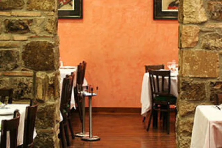 Room with orange walls and exposed stones at Passadís del Pep.