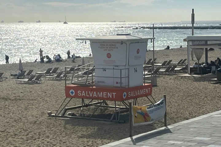 El puesto de socorro y las tumbonas de la playa del Bogatell, el mar resplandeciente detrás