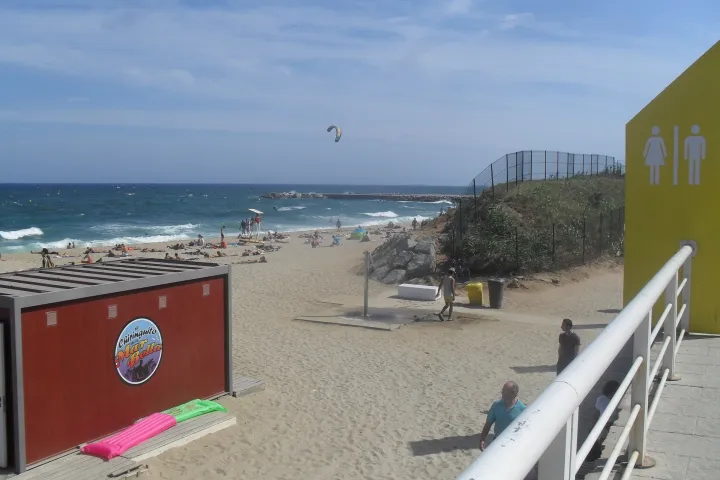 The promenade of Mar Bella Beach, a cyclist, and the service modules