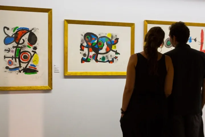 Two visitors in front of colorful artworks displayed at the Fran Daurel Museum