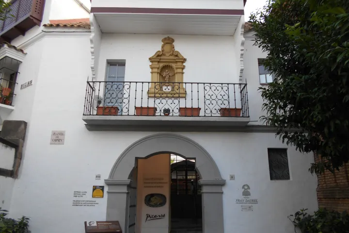 Entrance to the Fran Daurel Museum beneath a white façade with a balcony at Poble Espanyol