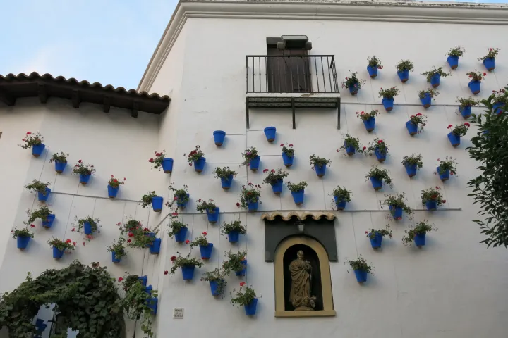 White façade and blue flower pots of the Plazuela del Carmen, in the Andalusian quarter of Poble Espanyol